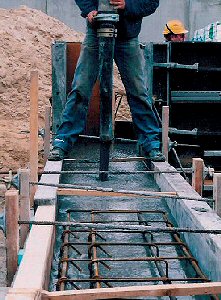 Billedet viser en mand i færd med at udstøbe beton