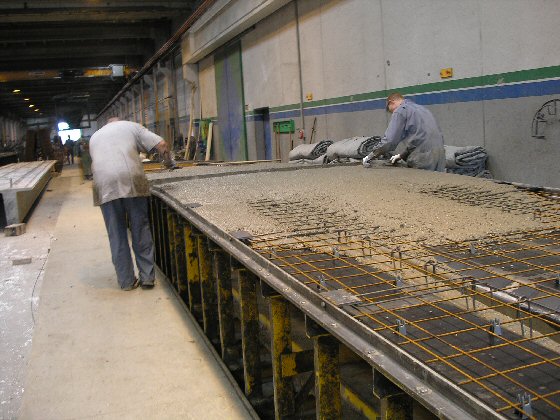 Til slut foretages afretning med stålskinne - en mand på hver side fordeler betonen med murerske.